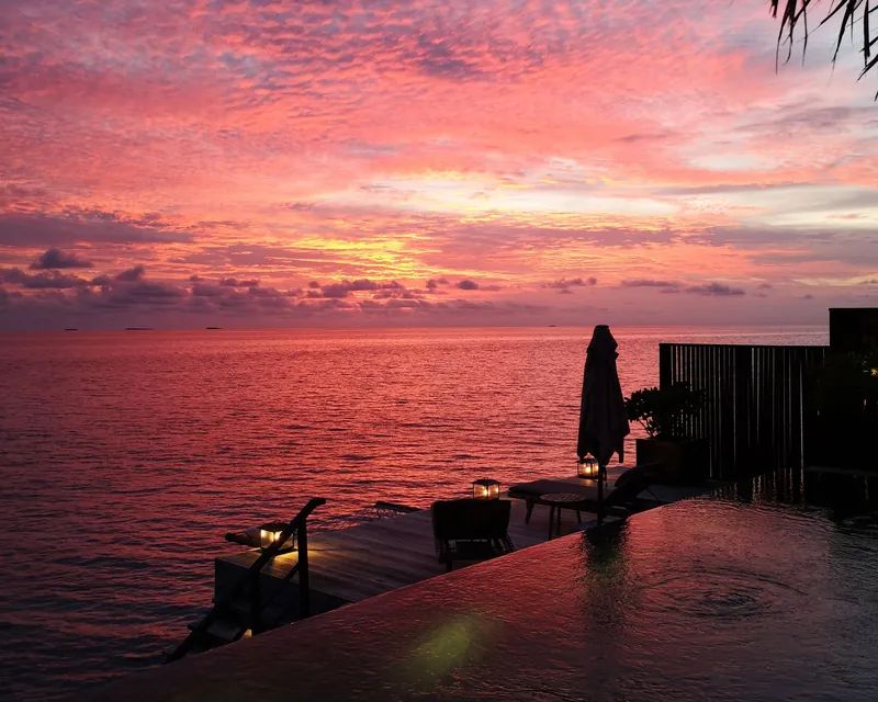 An infinity pool at sunset, over the sea