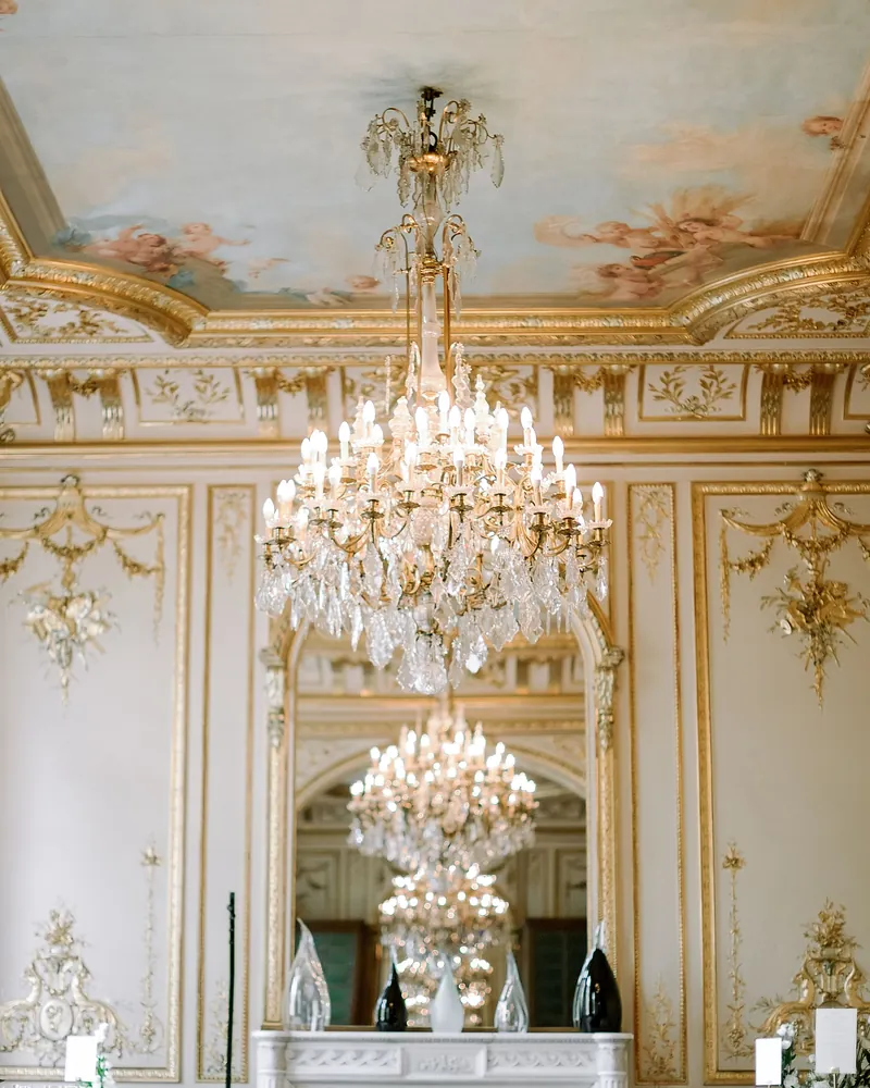 A gilded dining room under a crystal chandelier
