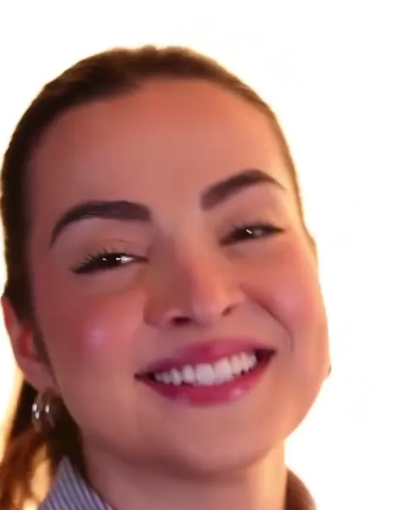 A smiling woman, her hair tied back