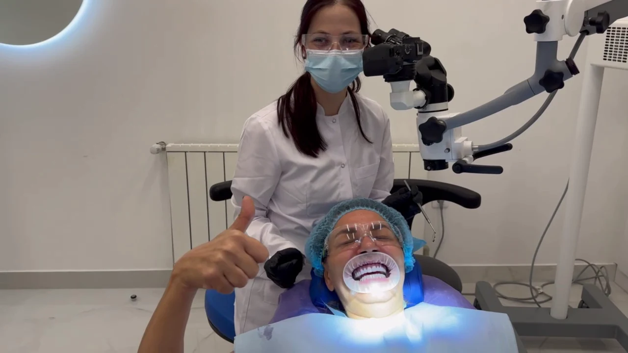 A dentist treating a patient under an operating microscope