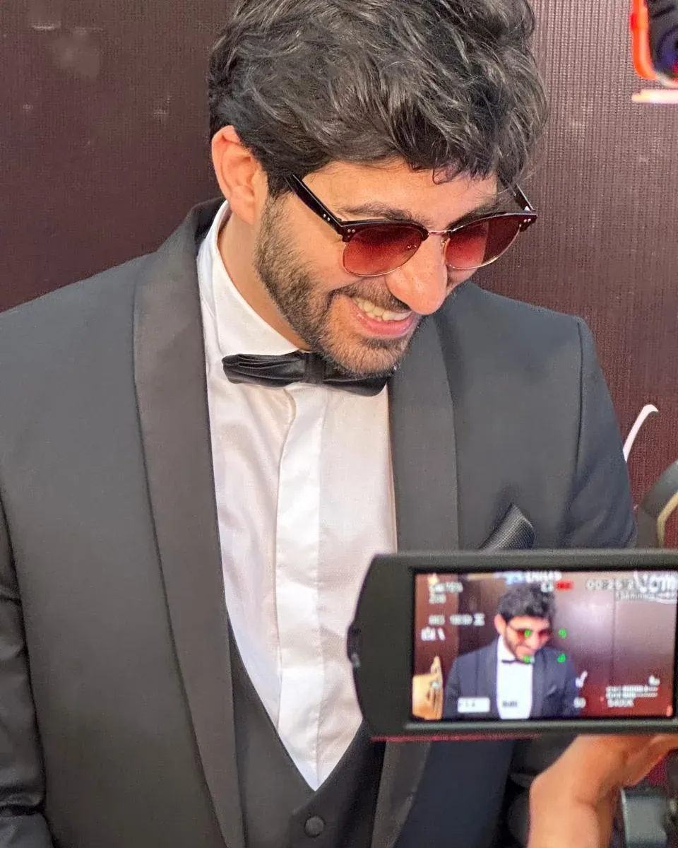 Dr. Elias Abou Tayeh in black tie, filmed by a camera crew