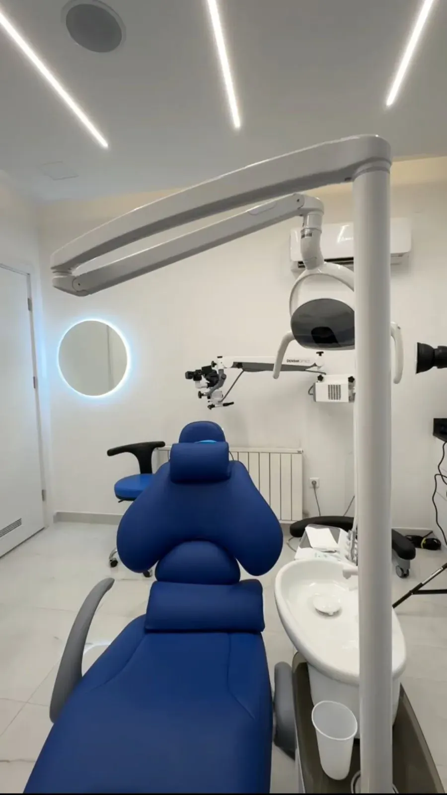 A treatment room at Mineers in Sofia: a blue chair, a microscope and white walls
