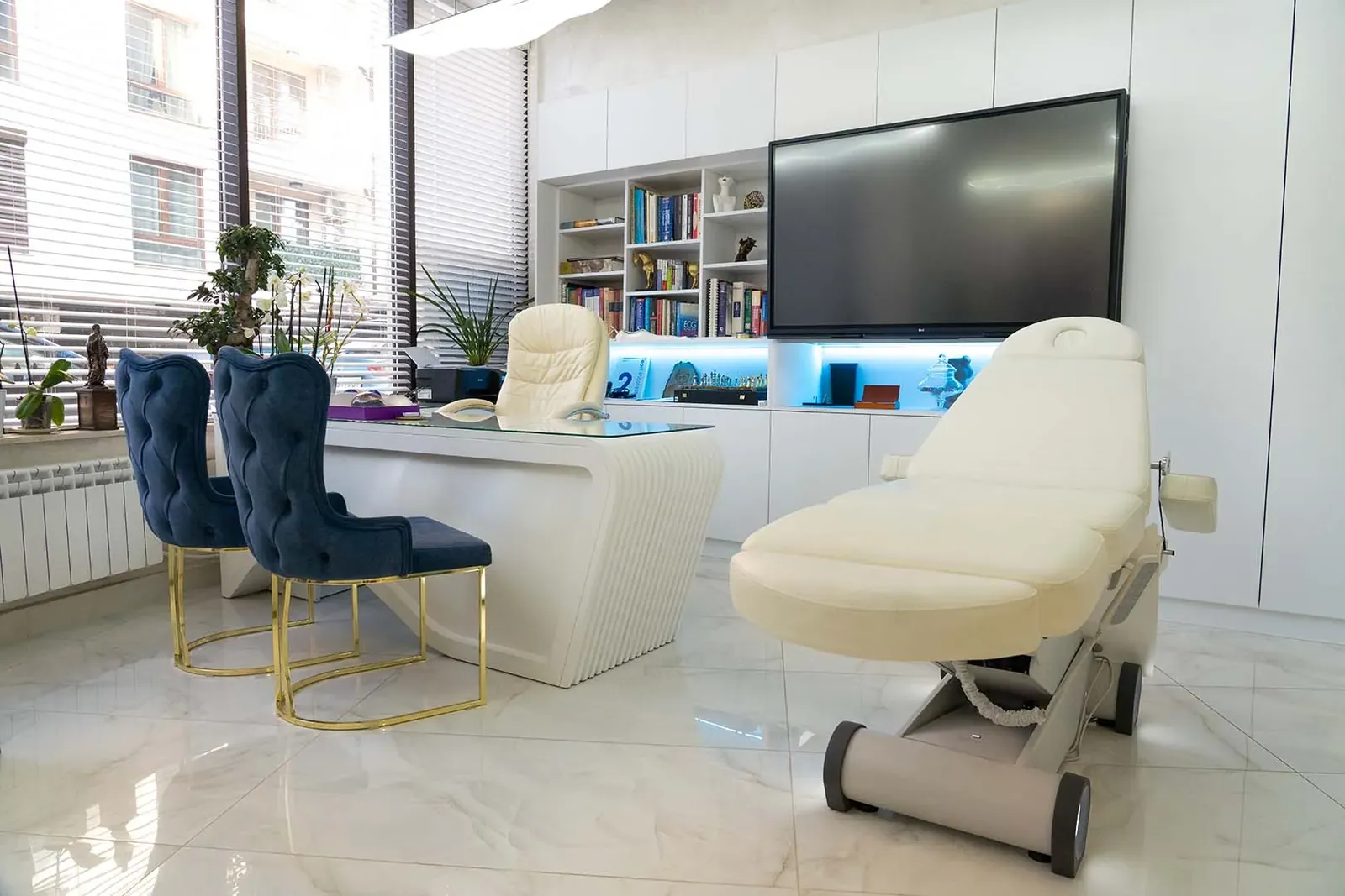 A consultation room at Mineers in Sofia: blue velvet chairs on a white marble floor