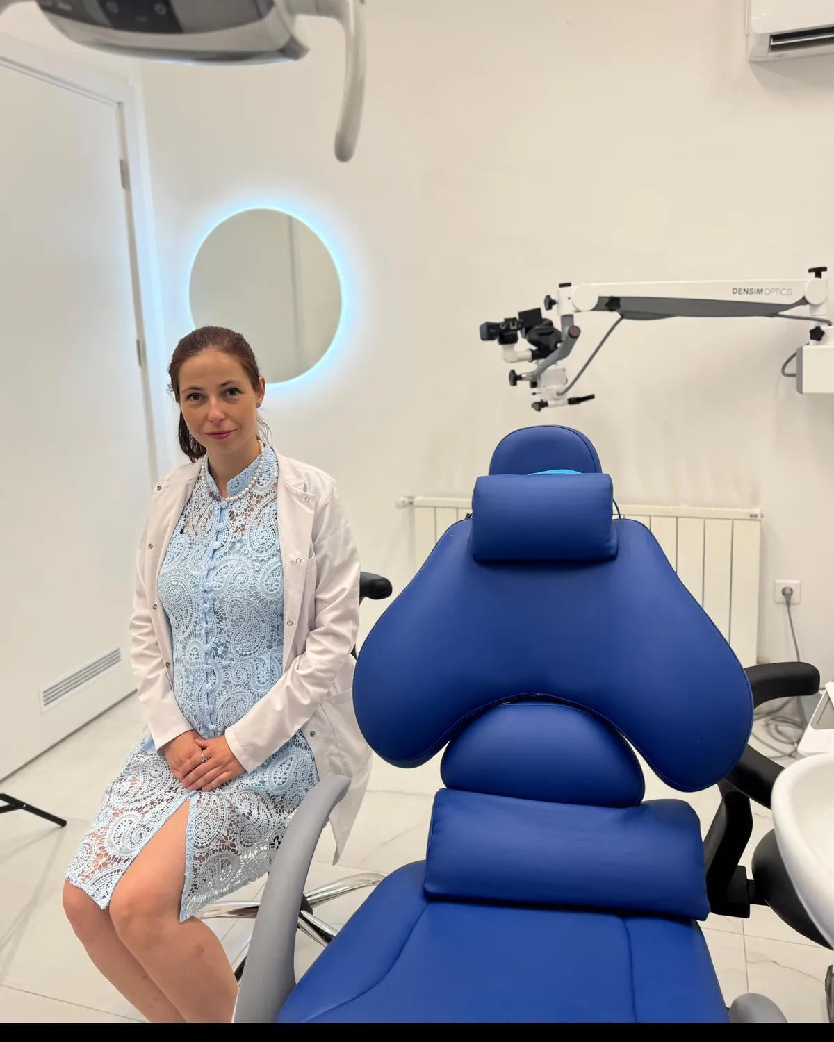 Dr. Milena Ilieva beside the treatment chair and the operating microscope at Mineers